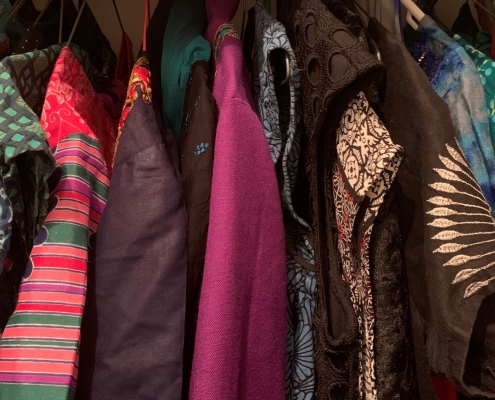 Colourful clothes hanging in a wardrobe